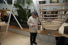 Auf dem Foto ist Joachim Steinbrück im Forum am Wall zu sehen. ER steht unter einer Treppe und demonstriert, wie schnell blinde Personen sich an der Treppenkonstruktion den Kopf stoßen können.