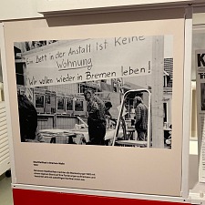 Plakat: Ein Bett in einer Anstalt ist keine Wohnung - Wir wollen wieder in Bremen leben!