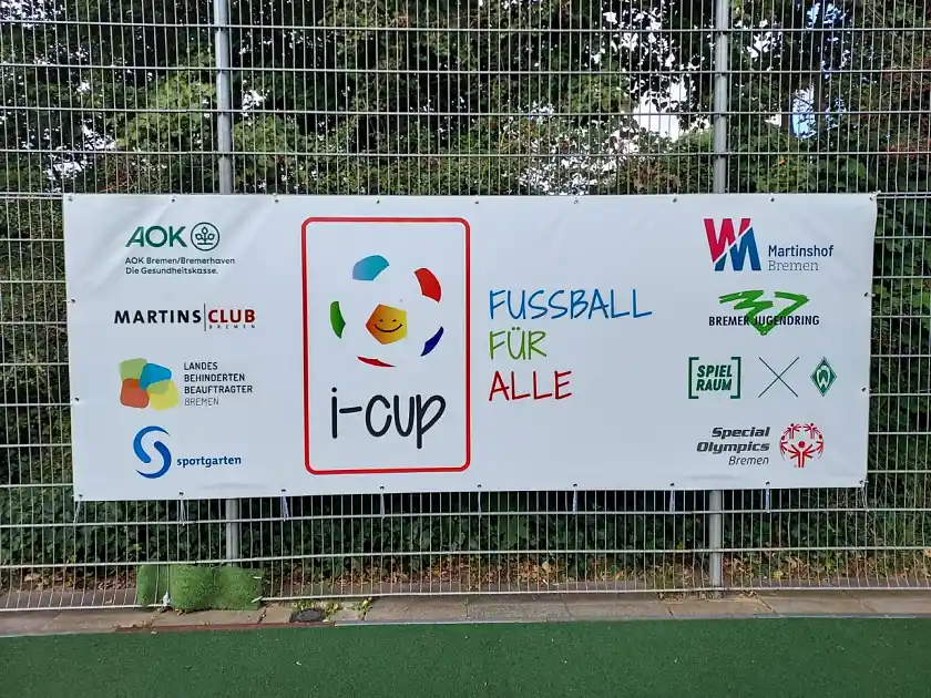 Am Zaun hängt ein Plakat mit all den teilnehmenden Organisationen