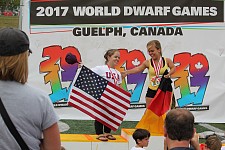 Das Bild zeigt eine Siegerehrung. Auf einem Podest stehen zwei Frauen nebeneinander. An den Länderflaggen erkennt man, dass Deutschland Gold und Amerika Silber gewonnen hat.