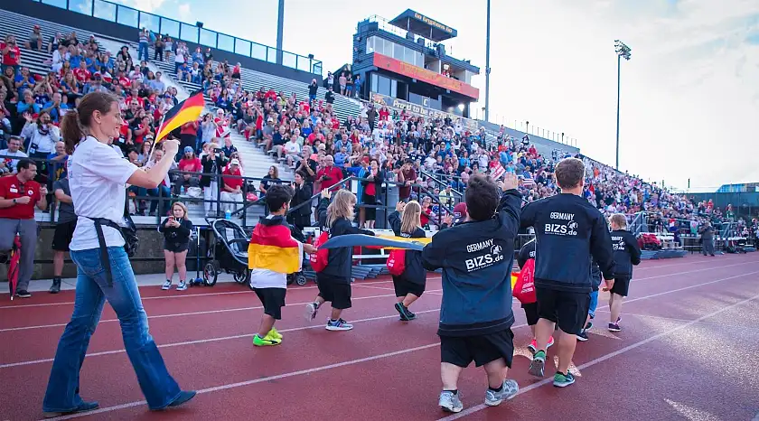 Auf dem Bild sind einige deutsche Athleten während der Siegerehrung in einem Stadion zu sehen.