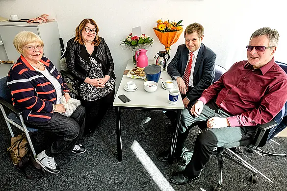 Auf der linken Seite eines Tisches sitzen Anja Stahmann und Hannelore Tempelmann. Auf der gegenüberliegenden Seite Bernd Giesecke sowie Joachim Steinbrück. Zwei Blumensträuße stehen am Ende des Tisches. Davor sind Kekse sowie Kaffeetassen zu sehen.