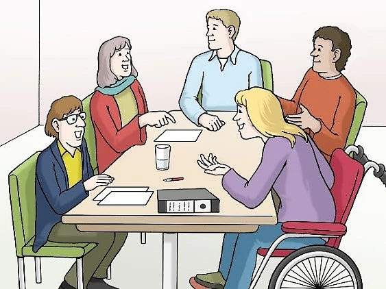 Menschen sitzen an einem Tisch. Sie unterhalten sich.