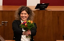 Özden Ohlsen hält einen bunten Blumenstrauss in den Händen