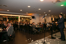 Jürgen Dusel während seiner Festrede. Das Publikums ist sitzend an Tischen zu sehen.