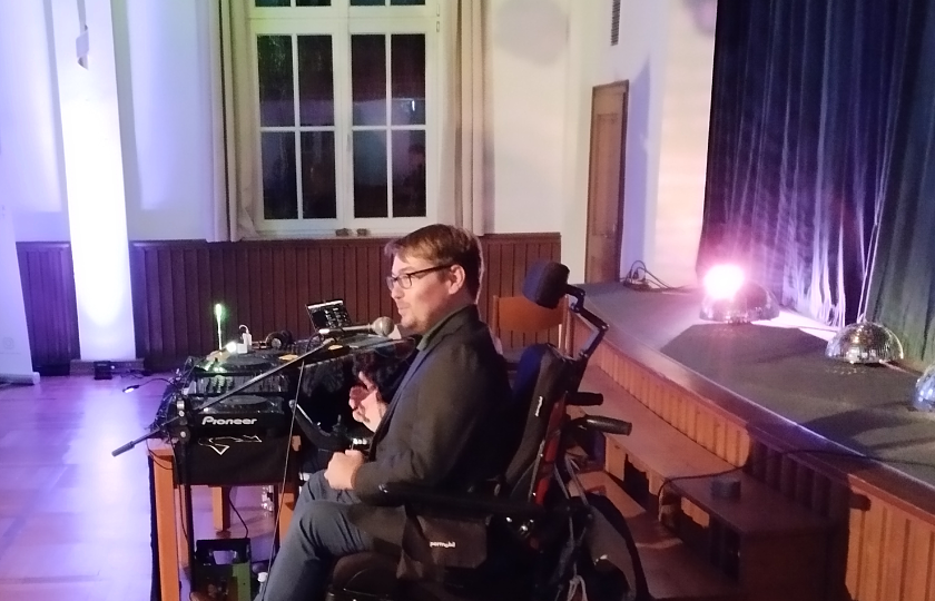 Arne Frankenstein vor der Bühne mit Discokugeln im Hintergrund