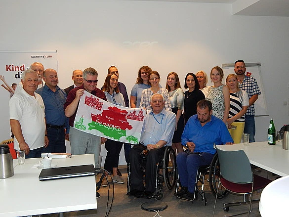 Abschieds-Gruppen-Foto. Joachim Steinbr&uuml;ck steht in der Mitte und h&auml;lt mir einem Gast aus Belarus sein Abschiedsgeschenk in die Kamera.