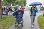 Zwei Teilnehmende mit Regenschirm auf dem Gelände
