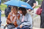 Zwei Teilnehmende unter einem Regenschirm