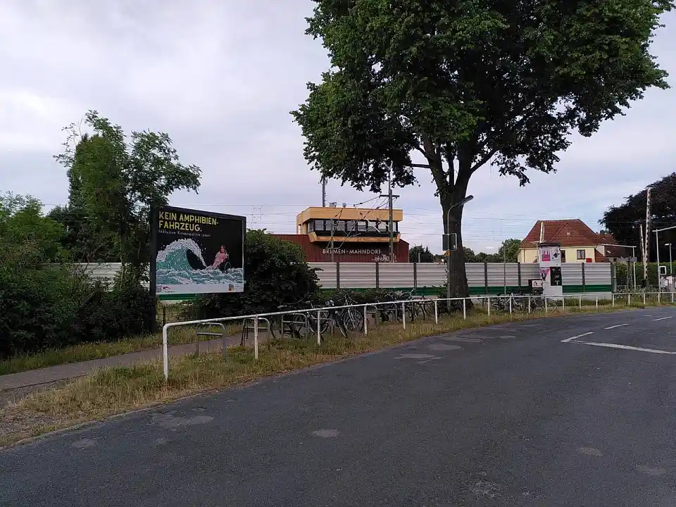 Das Plakat an einer baumbestandenen Strasse