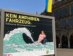 Plakat auf dem Marktplatz, im Hintergrund das Rathaus