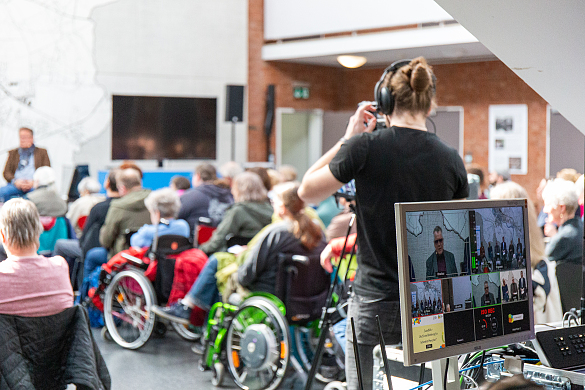 Foto zeigt einen Techniker und einen Teil des Publikums