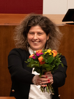 Özden Ohlsen hält einen bunten Blumenstrauß in den Händen